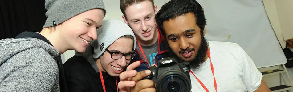 students looking a photograph on camera